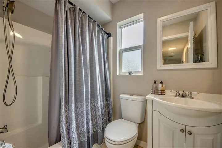 Full bathroom with vanity, toilet, and shower / bath combination with curtain