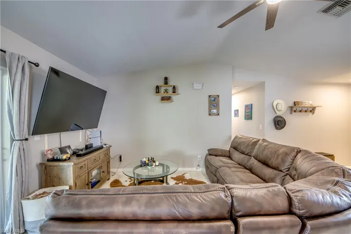 Living room featuring lofted ceiling and ceiling fan