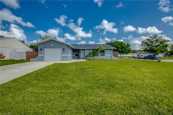 Ranch-style house featuring a garage and a front yard