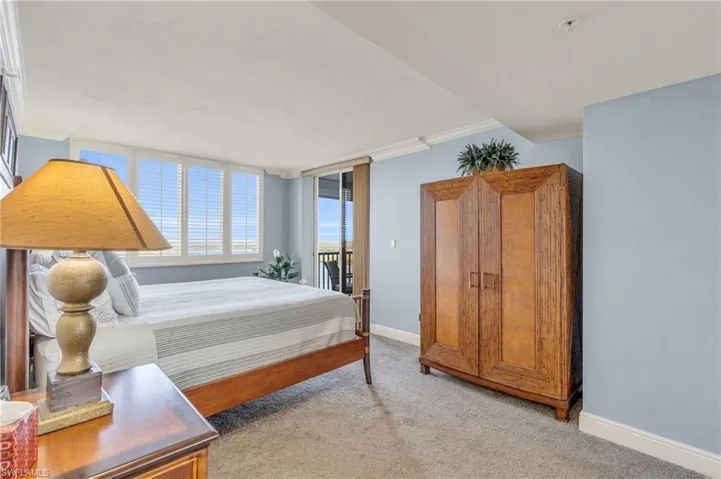Carpeted bedroom with crown molding / virtually enhanced image