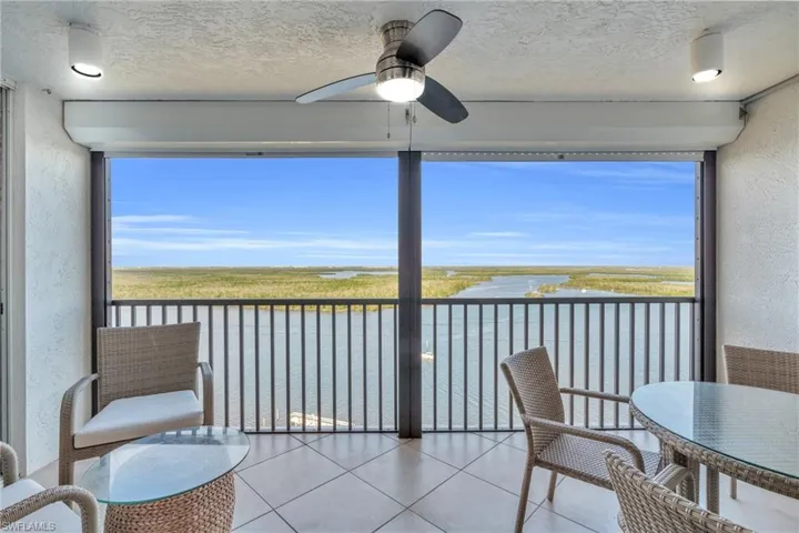 Sunroom / solarium with a water view and ceiling fan virtually enhanced image