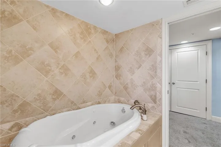 Bathroom with tiled tub and tile walls / virtually enhanced image