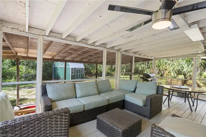 Wooden terrace featuring outdoor lounge area, a shed, and a grill