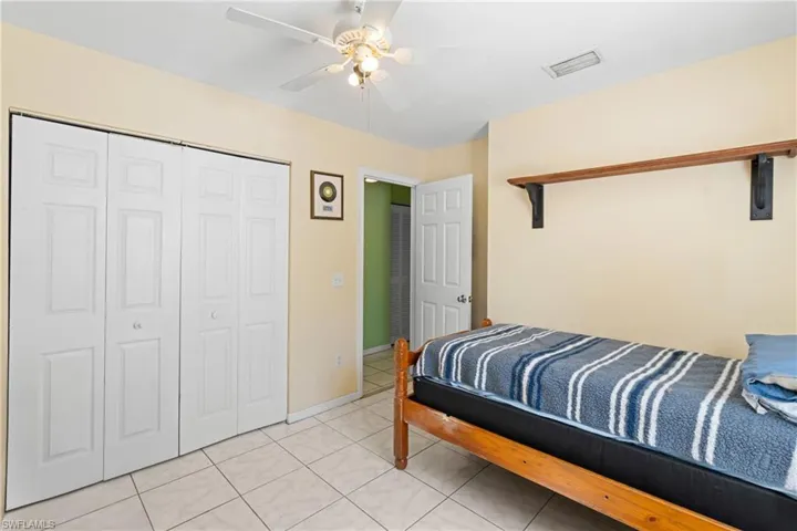 Bedroom featuring light tile patterned flooring, a closet, and ceiling fan