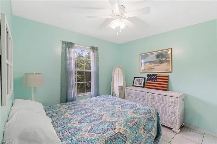 Bedroom with light tile patterned floors and ceiling fan