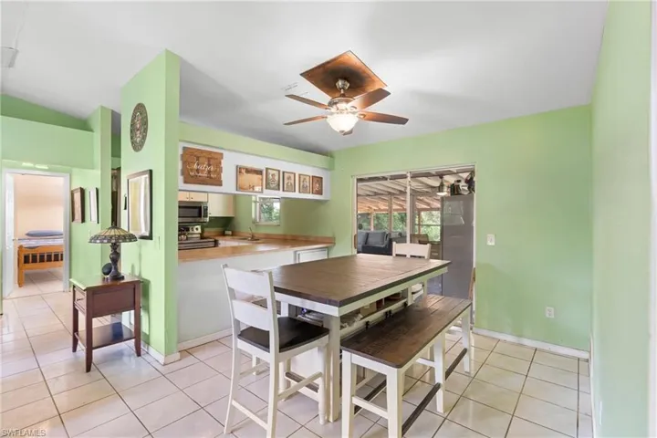 Dining area with light tile patterned flooring and ceiling fan