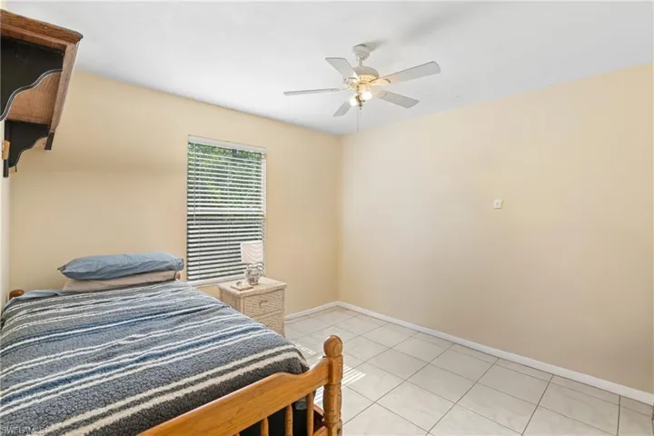 Bedroom featuring light tile patterned flooring and ceiling fan