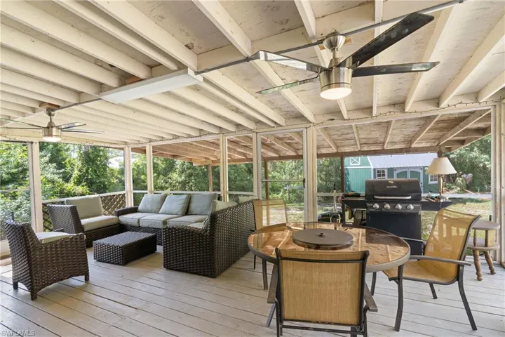Wooden deck with an outdoor hangout area, a ceiling fan, outdoor dining space, and a grill