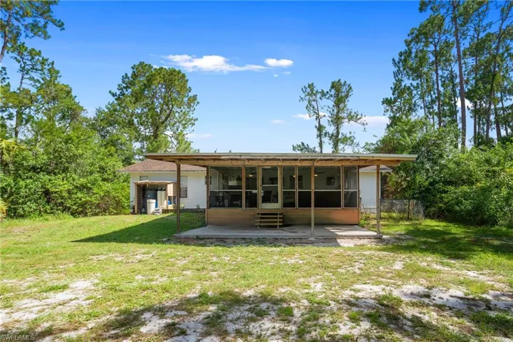 Rear view of property featuring a sunroom and a patio area