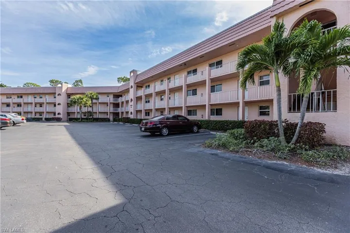 View of building / complex featuring uncovered parking