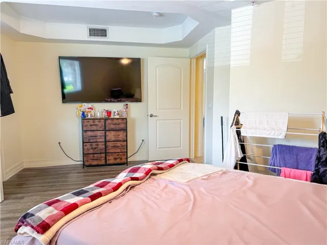 Bedroom featuring a raised ceiling and hardwood / wood-style flooring
