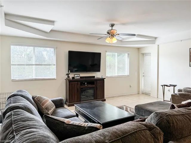 Living room featuring light tile patterned flooring and ceiling fan