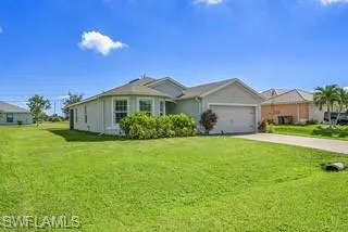 Ranch-style house with concrete driveway, a front yard, and a garage