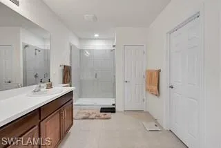Full bath featuring vanity, a shower stall, and light tile patterned floors