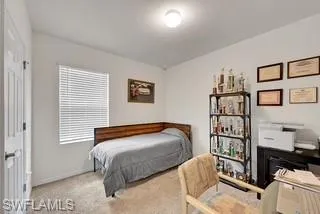 Bedroom with light colored carpet and baseboards