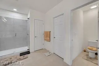 Full bath featuring a stall shower and light tile patterned flooring