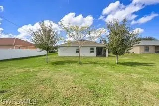 Rear view of property with a yard