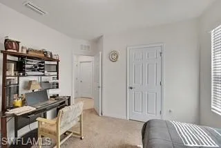 Office area with plenty of natural light and light colored carpet