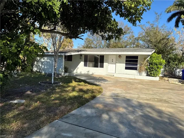 Cottage style home with stucco siding, concrete driveway, and a front yard