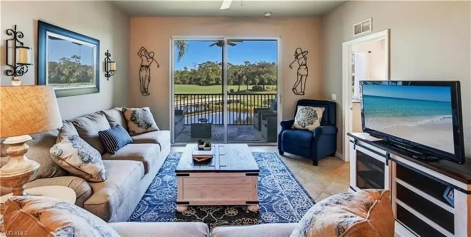 Living room with tile patterned floors and a ceiling fan
