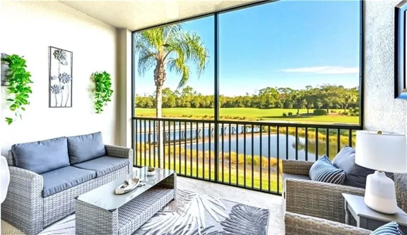 Sunroom / solarium with a water view, view of golf course, and view of scattered trees