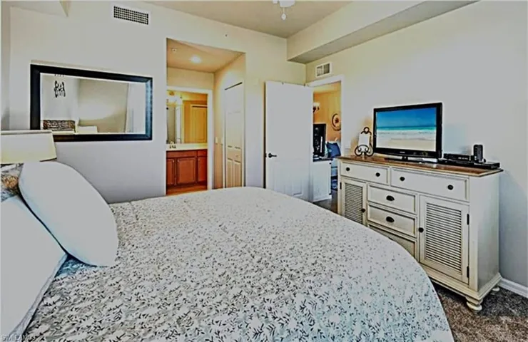 Bedroom featuring ensuite bathroom and a ceiling fan