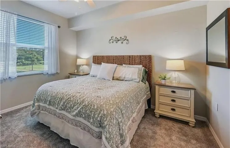 Bedroom featuring a ceiling fan and dark colored carpet