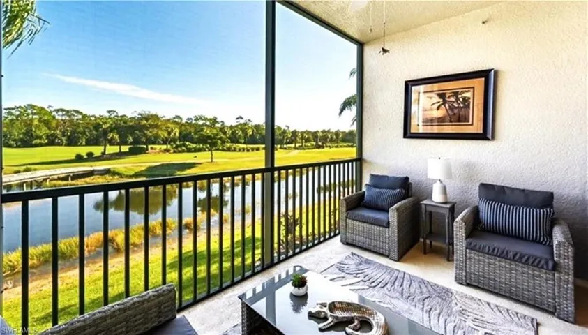 Sunroom / solarium with golf course view, outdoor lounge area, and a water view