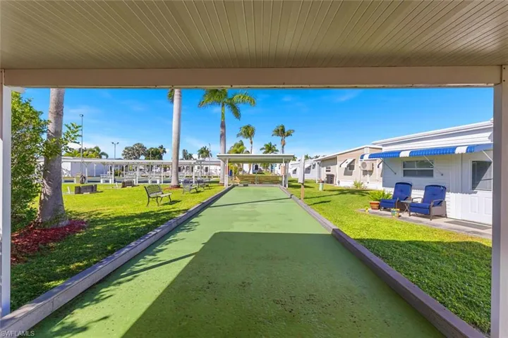 Surrounding community with a game area, a patio area, and a yard
