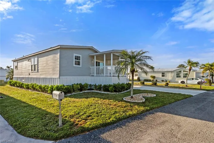 View of front of house with a front yard and a porch