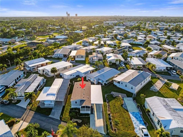 Aerial view of property and surrounding area featuring nearby suburban area