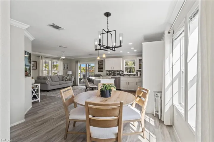 Dining space featuring crown molding, a chandelier, recessed lighting, light wood finished floors, and a ceiling fan
