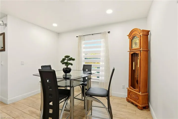 Recessed lighting, light-toned wall paint, wood-finish flooring, white window blinds, and white trim