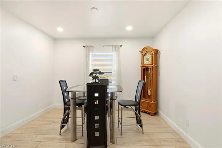 Recessed ceiling lighting, light wood-finish flooring, and white painted walls