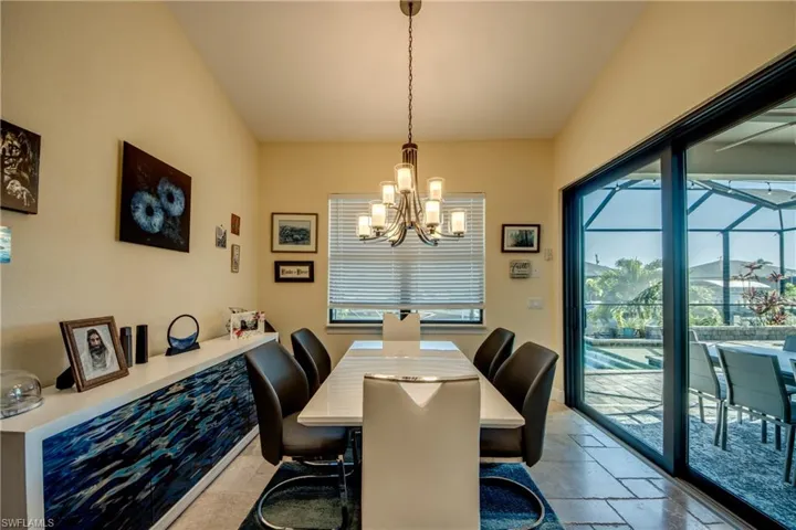 Dining space with stone tile floors, a chandelier, plenty of natural light, and a sunroom
