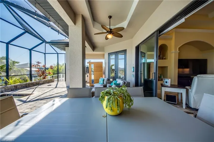 View of patio featuring a ceiling fan, a sunroom, a lanai, an outdoor hangout area, and french doors