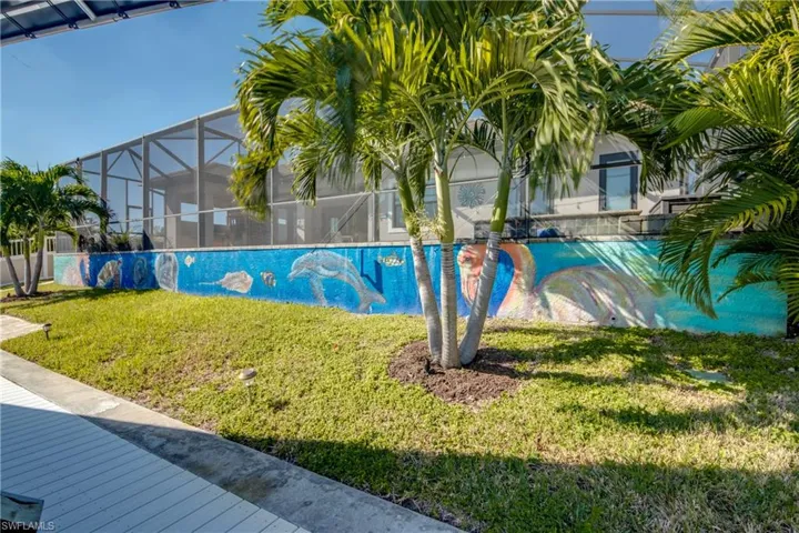 View of swimming pool with a lawn, glass enclosure, and a sunroom