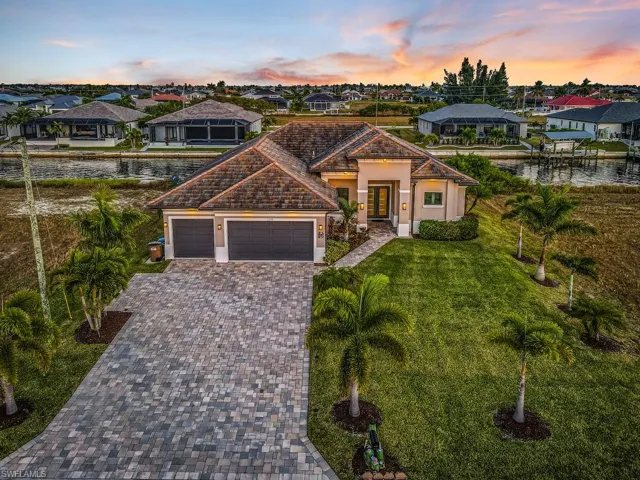 Mediterranean / spanish-style house with a residential view, decorative driveway, stucco siding, an attached garage, and a front yard
