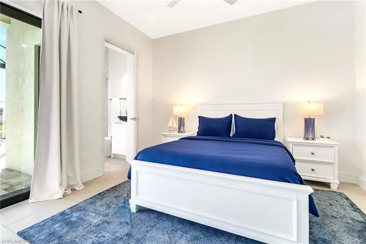 Bright bedroom featuring tile flooring and a sliding glass door