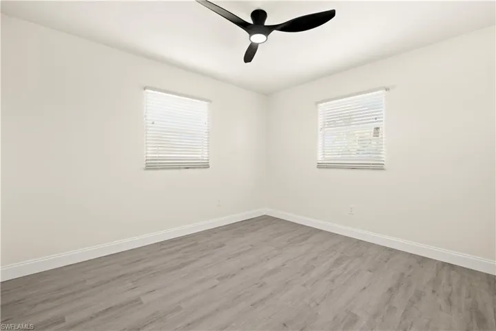Spare room with wood finished floors and a ceiling fan