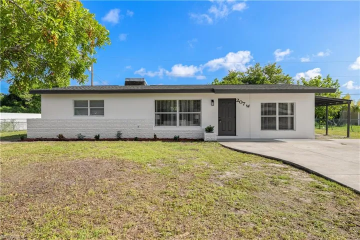 Ranch-style home with concrete driveway, brick siding, and stucco siding
