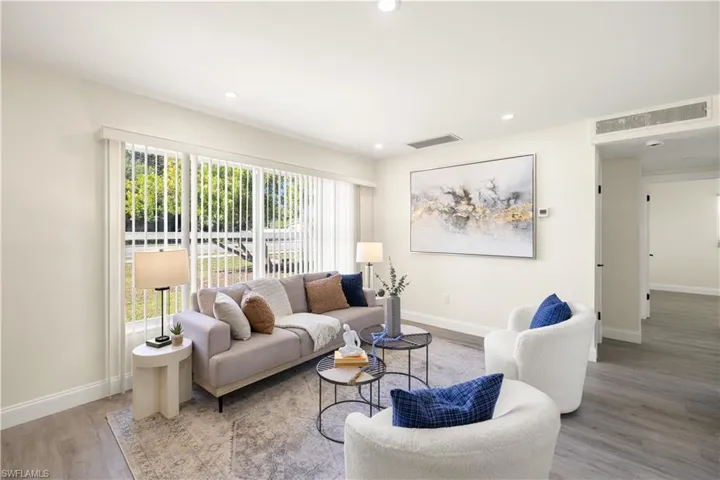 Living area with wood finished floors, plenty of natural light, and recessed lighting