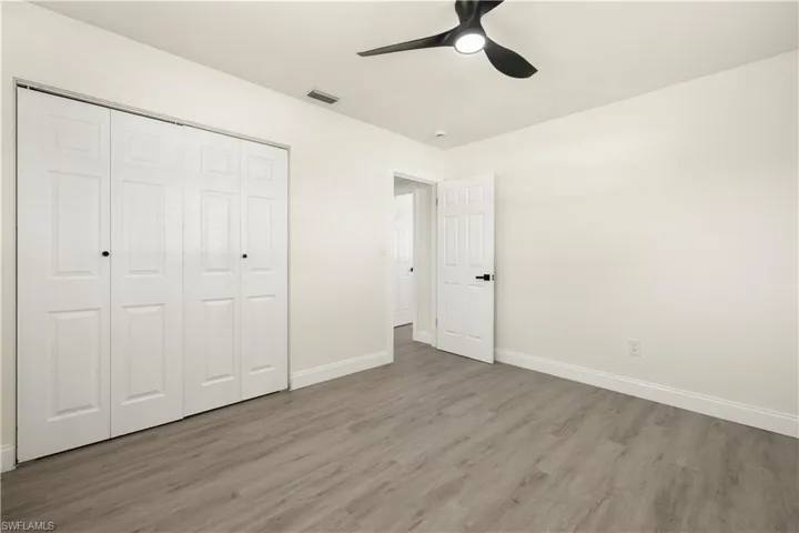 Unfurnished bedroom featuring light wood-type flooring, a closet, and ceiling fan