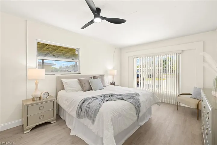 Bedroom with multiple windows, light wood-style flooring, access to exterior, and ceiling fan