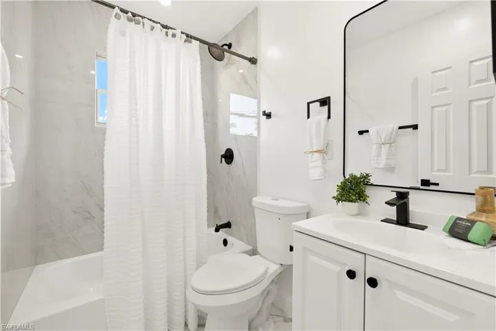 Bathroom with shower / bath combination with curtain and vanity