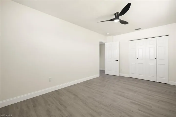 Unfurnished bedroom featuring wood finished floors, ceiling fan, and a closet