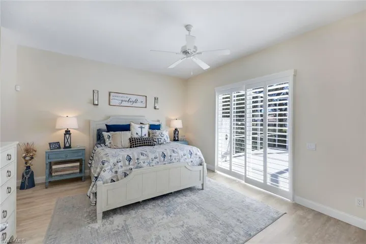 Spacious primary bedroom and white plantation shutters on sliding glass doors which lead to your private pool.