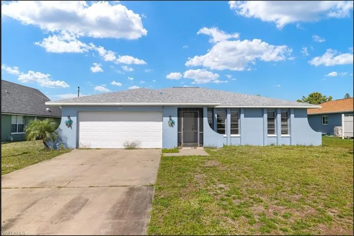 Ranch-style home featuring a garage and a front lawn