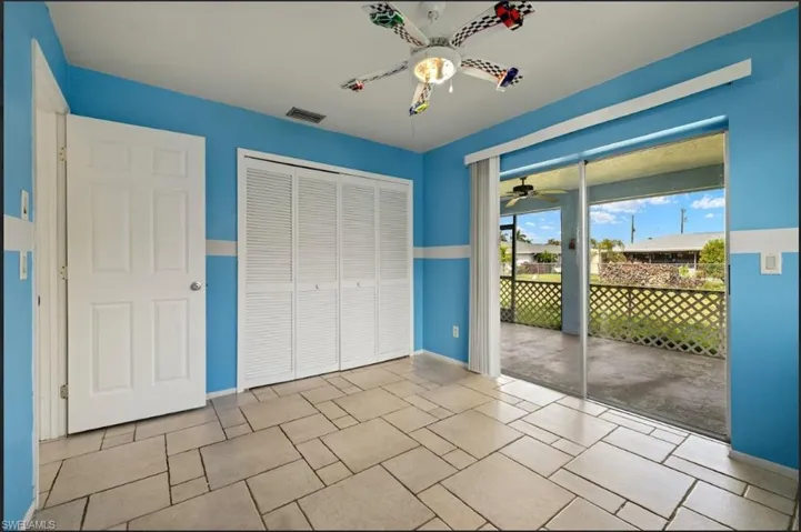 Unfurnished bedroom with ceiling fan, access to exterior, and a closet