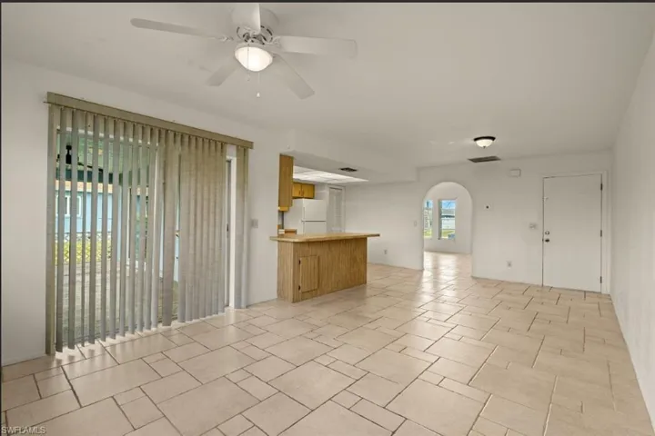 Unfurnished living room featuring ceiling fan